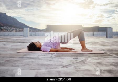 Yoga, woman and stretching for wellness, training and on yoga mat outdoor in sportswear. Health, young female and girl doing exercise workout Stock Photo