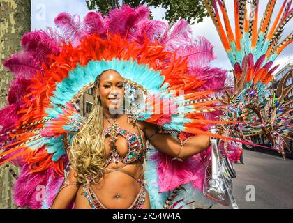 Samba dancer smiles in sparkly, feathered costume with, Notting Hill Carnival, London, UK Stock Photo