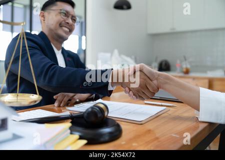 lawyer or attorneys shaking hand with client after consultation discussing a contract agreement customer at courtroom, judge service concept Stock Photo