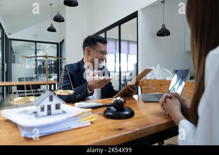 lawyer insurance broker consulting giving legal advice to couple customer about buying renting house. financial advisor with mortgage loan investment Stock Photo