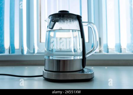 https://l450v.alamy.com/450v/2k551xw/pure-water-boils-in-an-electric-kettle-on-the-table-in-the-kitchen-2k551xw.jpg