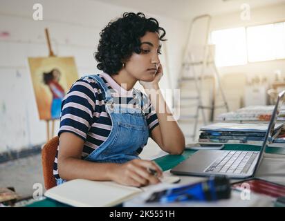 Thinking woman, laptop and writing notes for online art business with freelance artist in studio, workshop or showroom busy working on the internet Stock Photo