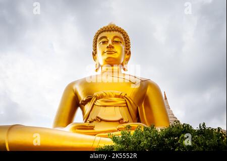 The giant golden Buddha looms large above the city of Bangkok Thailand at Wat Paknam. Temple full name; Wat Pak Nam Phasi Cheroen. Stock Photo