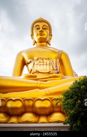 The giant golden Buddha looms large above the city of Bangkok Thailand at Wat Paknam. Temple full name; Wat Pak Nam Phasi Cheroen. Stock Photo