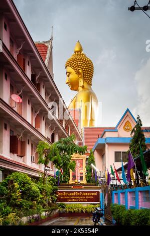 The giant golden Buddha looms large above the city of Bangkok Thailand at Wat Paknam. Temple full name; Wat Pak Nam Phasi Cheroen. Stock Photo