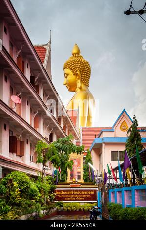 The giant golden Buddha looms large above the city of Bangkok Thailand at Wat Paknam. Temple full name; Wat Pak Nam Phasi Cheroen. Stock Photo