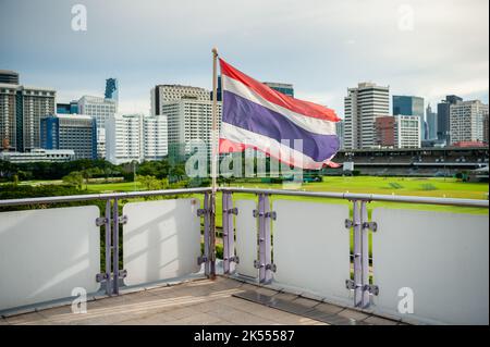 The Thailand flag flies on the platform of the BTS mass transit sky train station of Ratchadamri, Bangkok, Thailand. Stock Photo