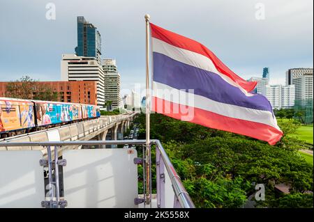 The Thailand flag flies on the platform of the BTS mass transit sky train station of Ratchadamri, Bangkok, Thailand. Stock Photo