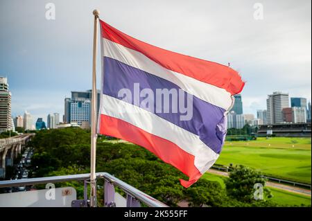 The Thailand flag flies on the platform of the BTS mass transit sky train station of Ratchadamri, Bangkok, Thailand. Stock Photo