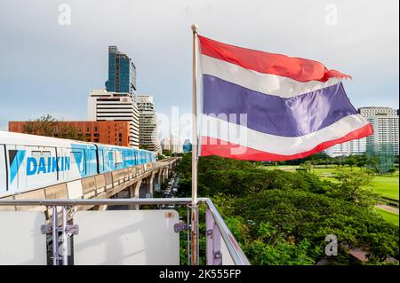 The Thailand flag flies on the platform of the BTS mass transit sky train station of Ratchadamri, Bangkok, Thailand. Stock Photo