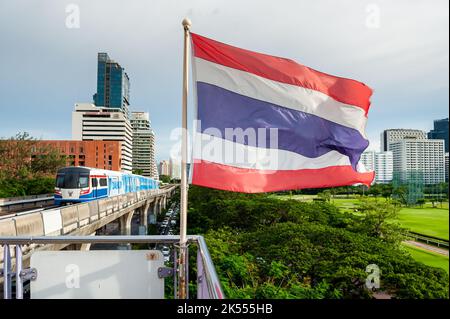 The Thailand flag flies on the platform of the BTS mass transit sky train station of Ratchadamri, Bangkok, Thailand. Stock Photo