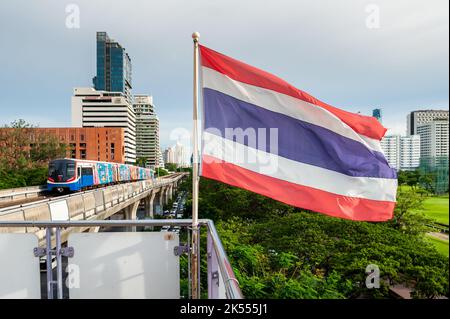 The Thailand flag flies on the platform of the BTS mass transit sky train station of Ratchadamri, Bangkok, Thailand. Stock Photo