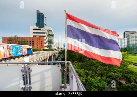 The Thailand flag flies on the platform of the BTS mass transit sky train station of Ratchadamri, Bangkok, Thailand. Stock Photo