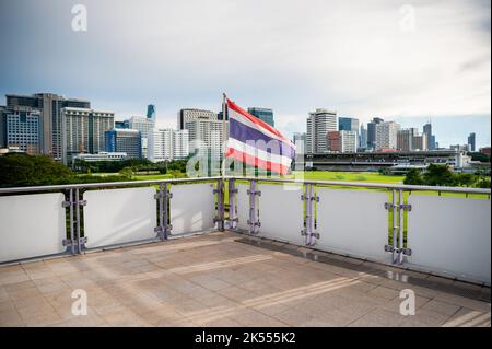 The Thailand flag flies on the platform of the BTS mass transit sky train station of Ratchadamri, Bangkok, Thailand. Stock Photo