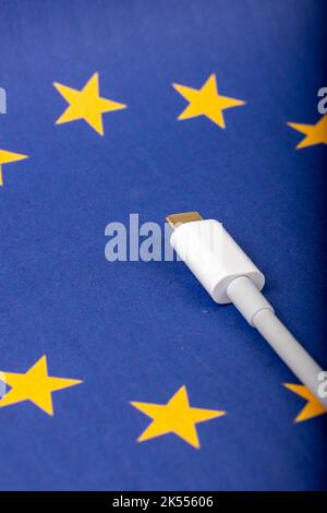 Concept for EU law to force USB-C chargers for all phones. EUROPEAN UNION flag and USBC universal charging cable as a standard for small electronic de Stock Photo