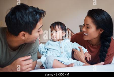 Down syndrome, mother and father bonding with child smile, happy and together at home for quality time. Family, man and woman with baby, kid and Stock Photo