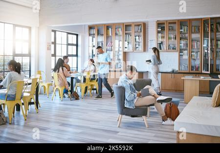Education, students and learning in library at university in relax, funky and creative study room. Diversity, college and learners in social space Stock Photo