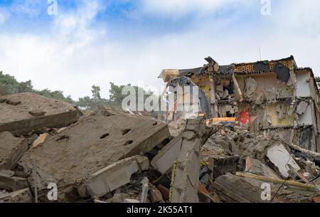 Process of demolition of old building dismantling. Excavator breaking house. Destruction of dilapidated housing for new development Stock Photo