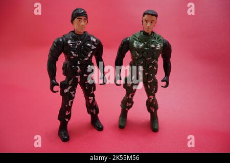 two soldier figurines arguing concept. armymen in green combat uniform Stock Photo