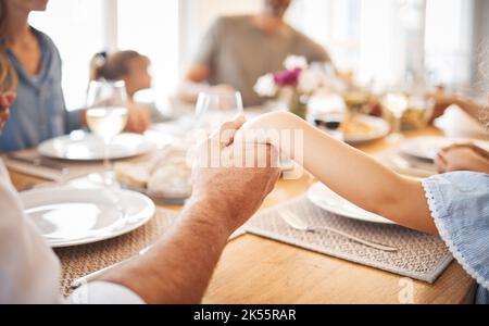Family, holding hands and thanksgiving lunch prayer in house, home and restaurant with men, women and children. Zoom, worship praying community with Stock Photo