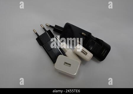 many phone charger adapters of different types on a white background Stock Photo