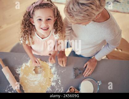 Food, family and portrait of girl baking with grandmother in kitchen, happy, relax and prepare cookies together. Learning, growth and child Stock Photo