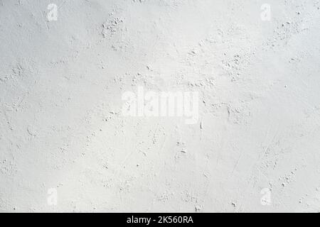 White gray plastered wall background. White concrete background close up. Abrasive white cement background in the rays of the sun with shadows Stock Photo