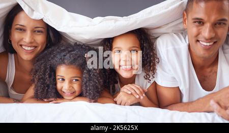 Portrait of happy black family bonding on a bed, relax and smile in a bedroom together. Love, blanket and happiness parents enjoying free time with Stock Photo