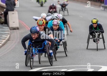 Merle Menje wheelchair athlete racing in the TCS 2022 London Marathon elite wheelchair race in Tower Hill, London, UK. Leading a group of athletes Stock Photo