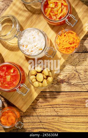 Lecho, sauerkraut, ajvar, korean carrot, olives in glass jars Stock Photo