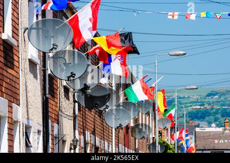 BELFAST, NORTHERN IRELAND. 04 JUN 2016: Houses in Iris Drive in West Belfast are decorated with the flags of all 24 countries that have qualified for the Euros 2016.  The residents organised a sweepstake, with each house having to fly the flag of their country.  It is believed to be the first time that the England and Northern Ireland flags have been flown voluntarily in this staunchly republican area of West Belfast. Stock Photo