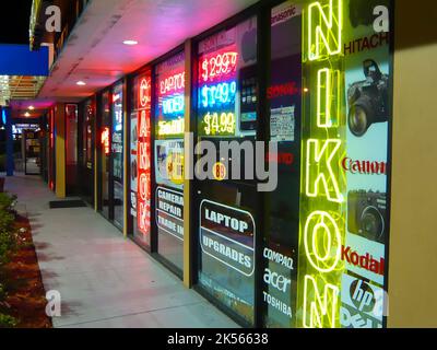 Outside a camera shop with neon signs for Canon and Nikon Stock Photo