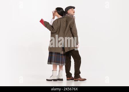 Portrait of young man and woman wearing the same jacket isolated over white studio background Stock Photo