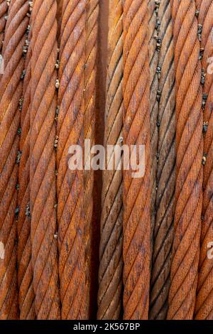 Close up of rusty steel cable coiled on a drum. Stock Photo