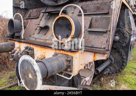 Drive transmission mechanism in a historic and damaged steam locomotive standing on a sidetrack. Stock Photo