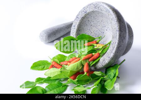 Mortar and herbs, chili isolated on white background.polished mortar. Stock Photo