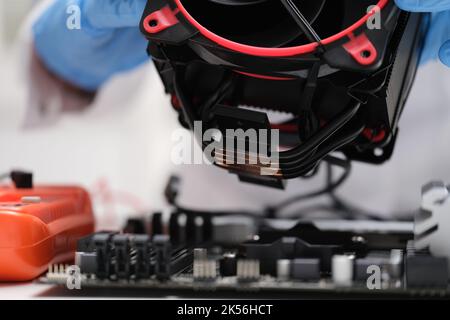 Technician installs air-cooled cooler on desktop processor Stock Photo