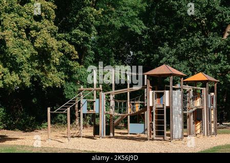 Children's wooden playground recreation area at public park. Children's playground, swing, slide, stairs. A place for children to play. Gymnastics Stock Photo