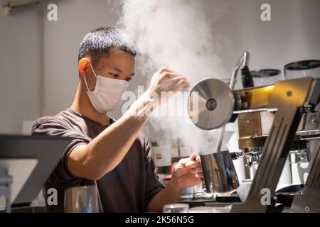 (221006) -- CHONGQING, Oct. 6, 2022 (Xinhua) -- A young entrepreneur makes coffee for clients in a coffee bar at Daijiaxiang alley in Yuzhong District, southwest China's Chongqing, Sept. 24, 2022.  In recent years, Chongqing has rebuilt and renovated a large number of idle and abandoned buildings in Yuzhong District.    The renewed buildings and neighborhoods have attracted many young entrepreneurs to start their business in catering, cultural and creative industries, and also helped promote tourism in Chongqing. (Xinhua/Tang Yi) Stock Photo