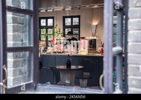 (221006) -- CHONGQING, Oct. 6, 2022 (Xinhua) -- A staff member makes coffee in a commercial complex reconstructed from an old building in Yuzhong District, southwest China's Chongqing, Oct. 6, 2022.  In recent years, Chongqing has rebuilt and renovated a large number of idle and abandoned buildings in Yuzhong District.    The renewed buildings and neighborhoods have attracted many young entrepreneurs to start their business in catering, cultural and creative industries, and also helped promote tourism in Chongqing. (Xinhua/Tang Yi) Stock Photo