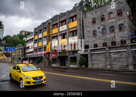 (221006) -- CHONGQING, Oct. 6, 2022 (Xinhua) -- A taxi is seen outside a commercial complex reconstructed from an old building in Yuzhong District, southwest China's Chongqing, Oct. 6, 2022.  In recent years, Chongqing has rebuilt and renovated a large number of idle and abandoned buildings in Yuzhong District.    The renewed buildings and neighborhoods have attracted many young entrepreneurs to start their business in catering, cultural and creative industries, and also helped promote tourism in Chongqing. (Xinhua/Tang Yi) Stock Photo