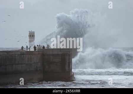 Porto, Portugal - December 31, 2015: People watching storm in the Douro river mouth new pier and beacon. Stock Photo