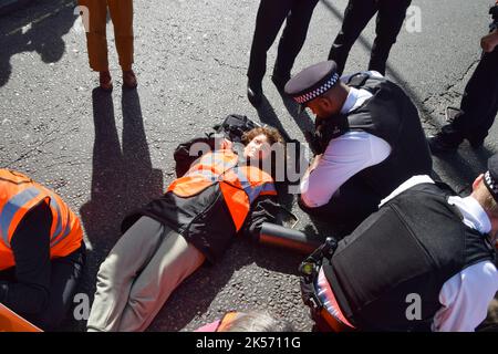 London, UK. 6th October 2022. Just Stop Oil protesters block Trafalgar Square. Some activists glued their hands to the road, while others attached themselves to metal pipes, and the protest was part of a series of demonstrations taking place daily in Westminster, with the climate action group demanding an end to fossil fuels and a switch to renewables. Credit: Vuk Valcic/Alamy Live News Stock Photo