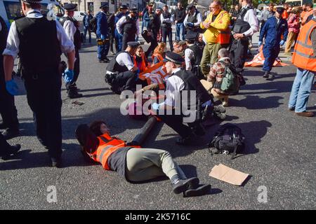 London, UK. 6th October 2022. Just Stop Oil protesters block Trafalgar Square. Some activists glued their hands to the road, while others attached themselves to metal pipes, and the protest was part of a series of demonstrations taking place daily in Westminster, with the climate action group demanding an end to fossil fuels and a switch to renewables. Credit: Vuk Valcic/Alamy Live News Stock Photo