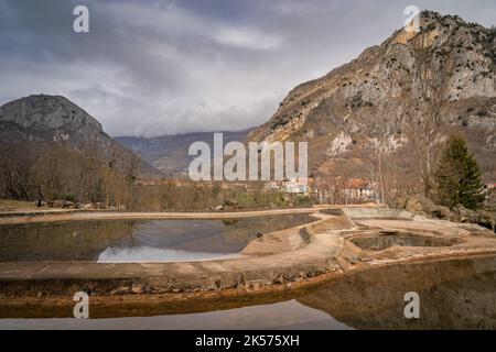 Mountains and trees reflecting in artificial ponds. Surba town hiding behind trees at the foothill of Pyrenees Mountains Tarascon sur Ariege France Stock Photo