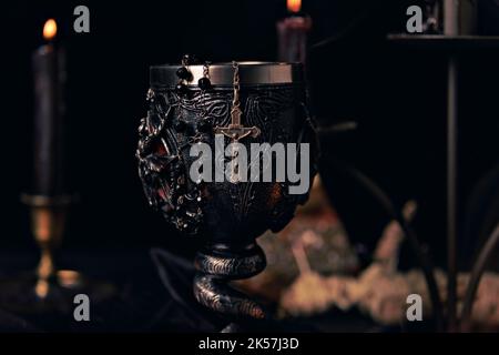 Voodoo Magic concept. Voodoo doll studded with needles with pierced rag heart on pentagram and around burning candles. Spooky or eerie magical Stock Photo
