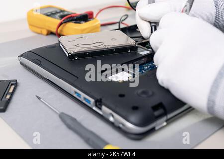 Technician hands repairing a laptop computer. Close up Stock Photo