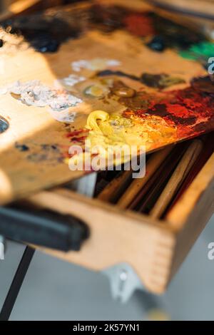 Used Artist paint brush and palette of colorful oil paint on