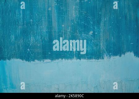 Grunge abstract beautiful bright blue wall with cracks in the plaster and several levels of paint application. Background with space for text or image. The art of rough stylized texture. Stock Photo