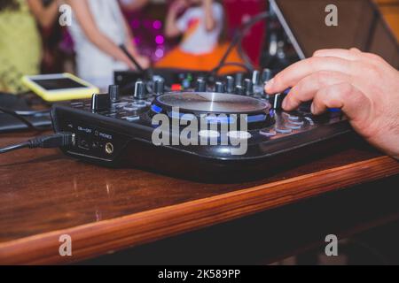DJ Hands creating and regulating music on dj console mixer in concert outdoor.DJ mixer controller panel for playing music and partying. Stock Photo